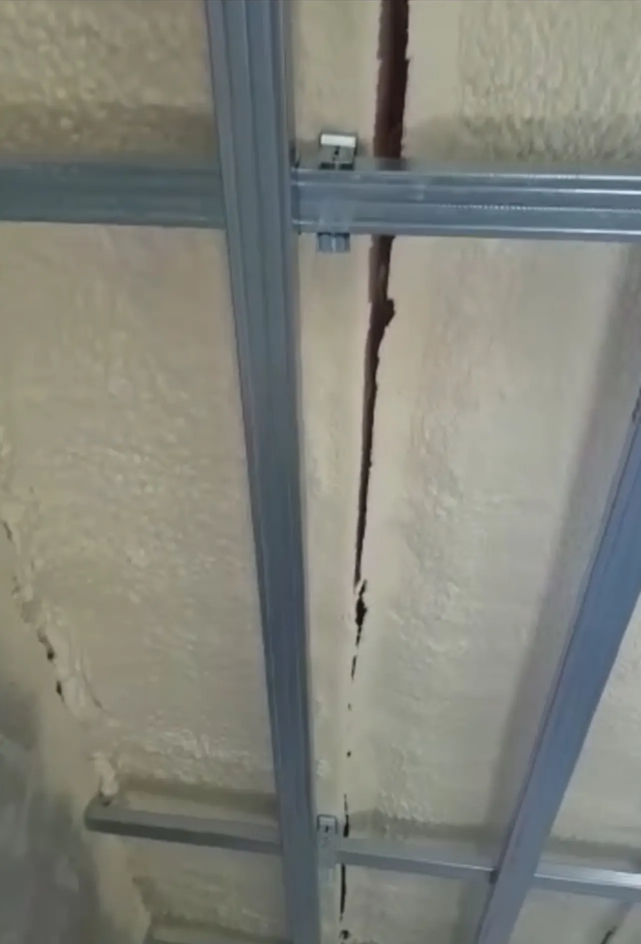 Spumă poliuretanică în spatele unei structuri metalice pentru gips-carton, cu o fisură verticală